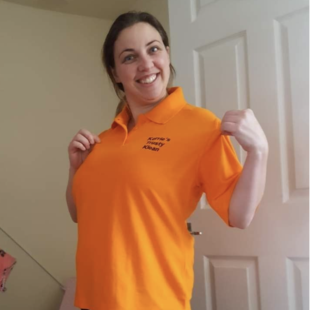 Kerrie smiling in her orange Kerrie's Trusty Klean polo shirt